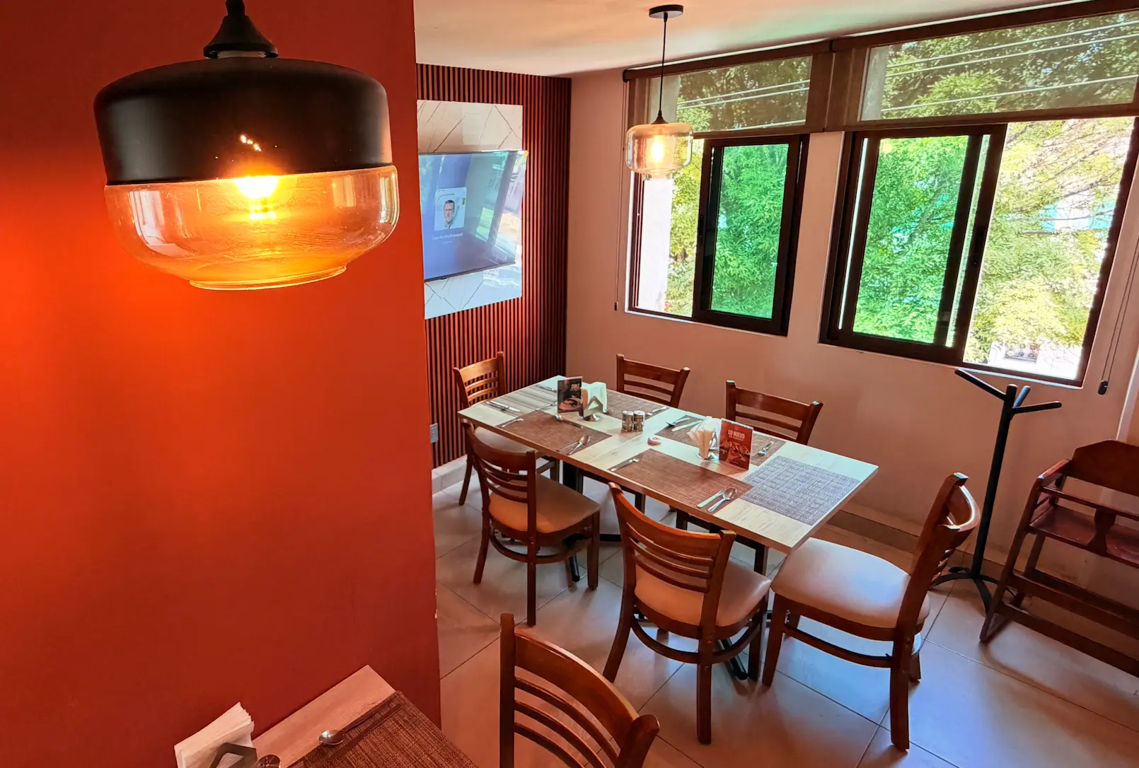 Salón de Cafetería El Yoyo con mesas, lámparas y ventanas amplias